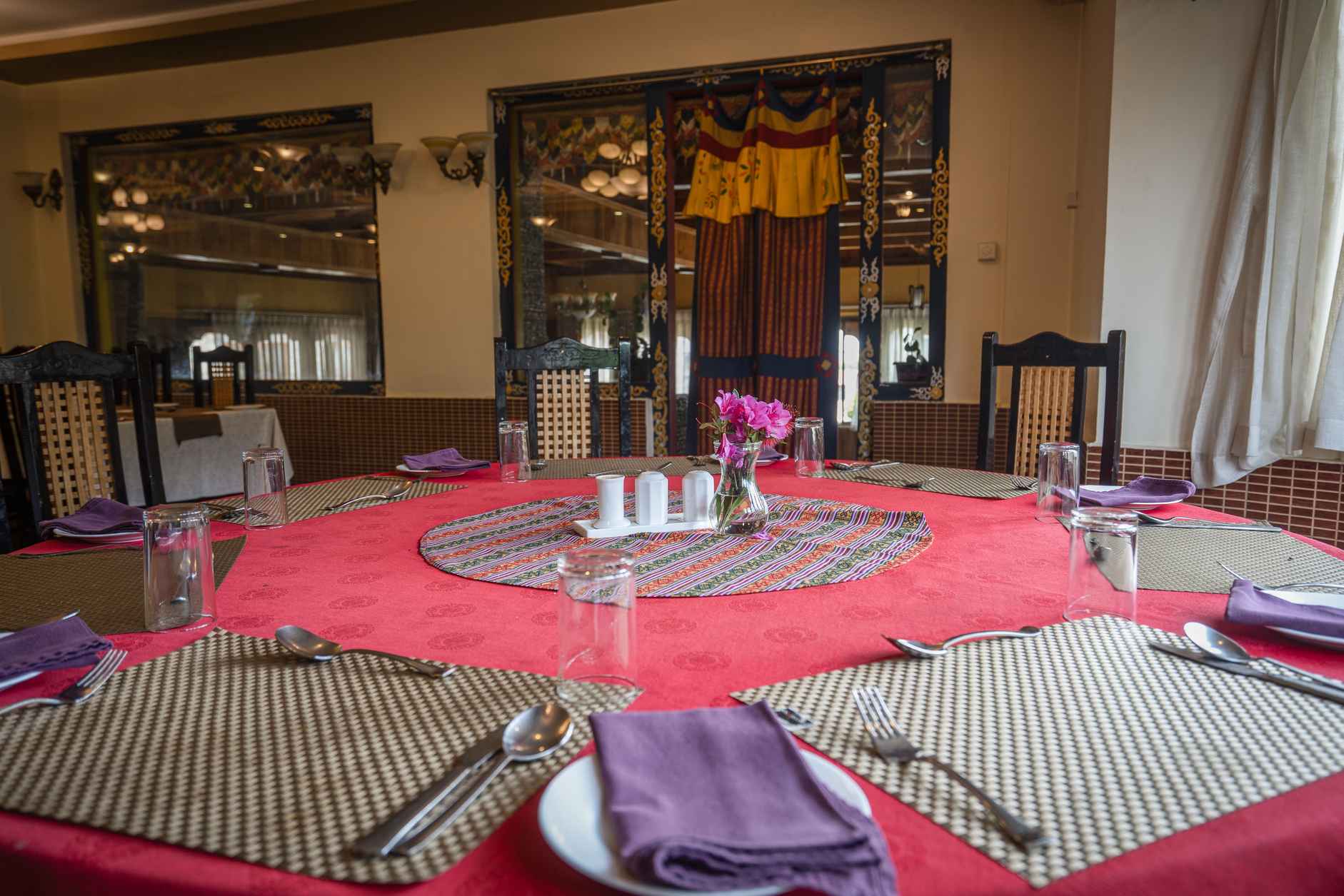 Indoor dining hall with timber ceiling and bar at Hotel Migmar